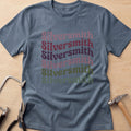Boho Script Silversmith jewelry maker t-shirt in Dark Heather, flat lay with jeweler's tools