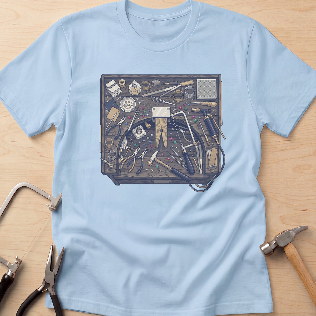 Jeweler's Bench jewelry maker t-shirt in Light Blue, flat lay with jeweler's tools