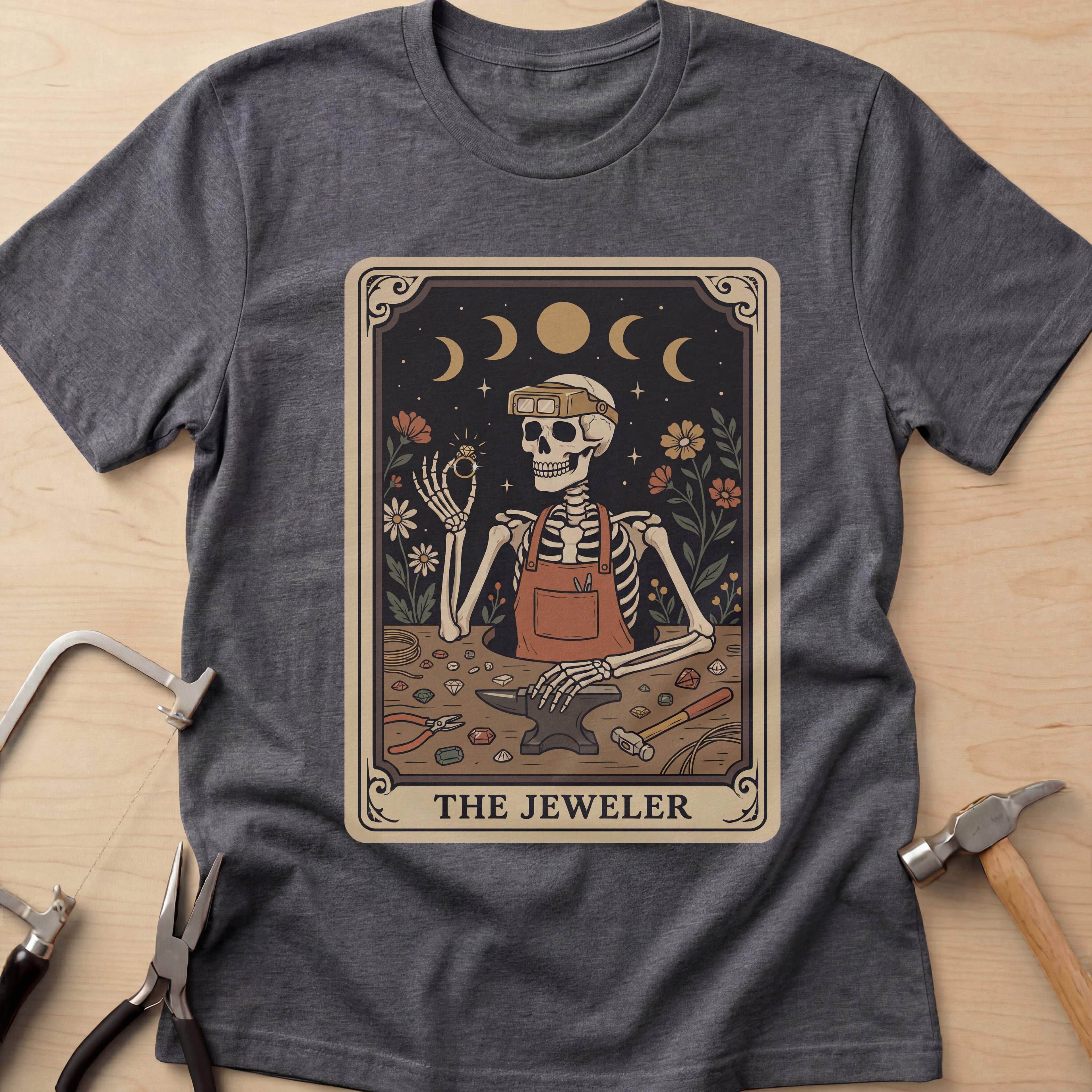 The Jeweler Tarot (Daisies) jewelry maker t-shirt in Dark Heather Grey, flat lay with jeweler's tools