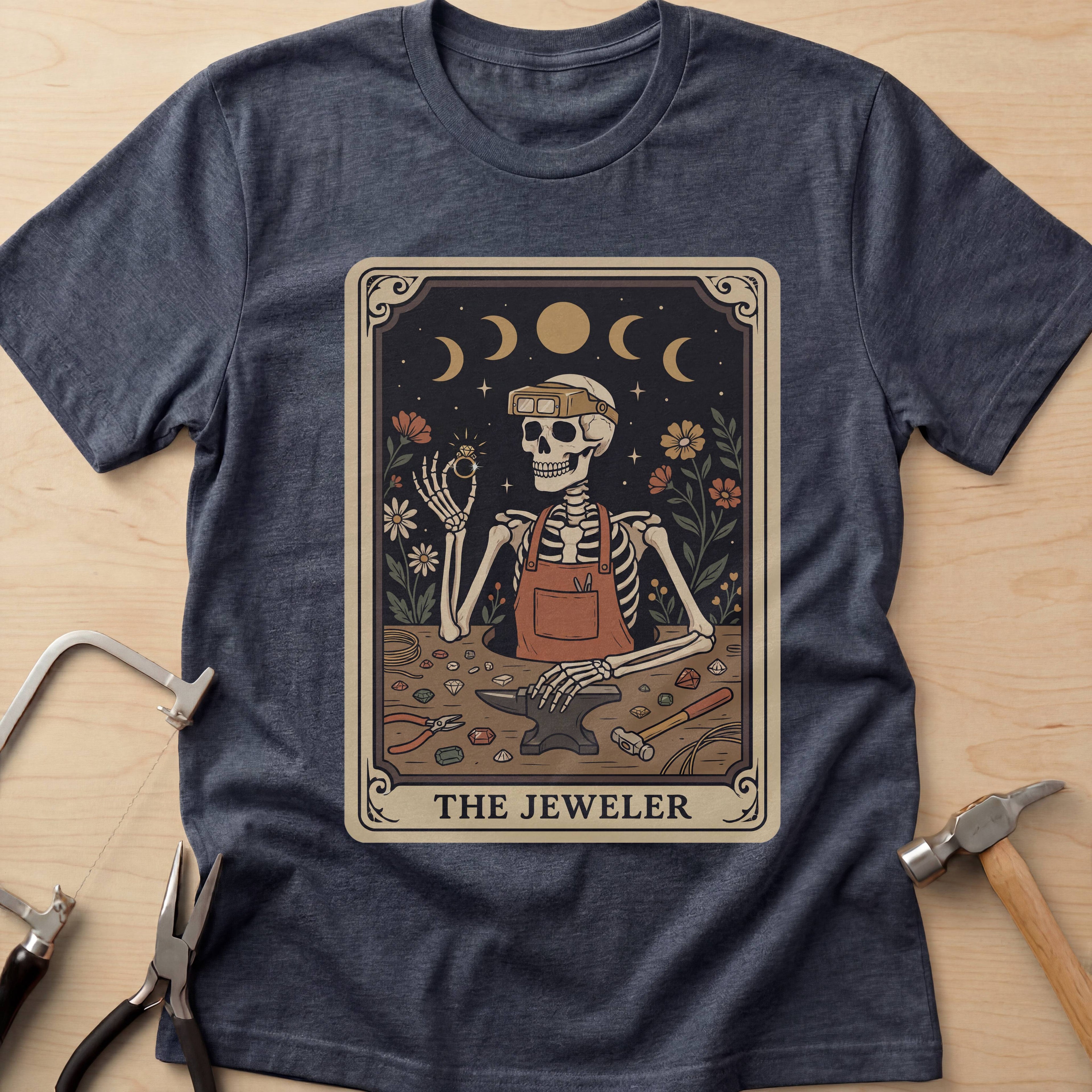 The Jeweler Tarot (Daisies) jewelry maker t-shirt in Heather Navy, flat lay with jeweler's tools