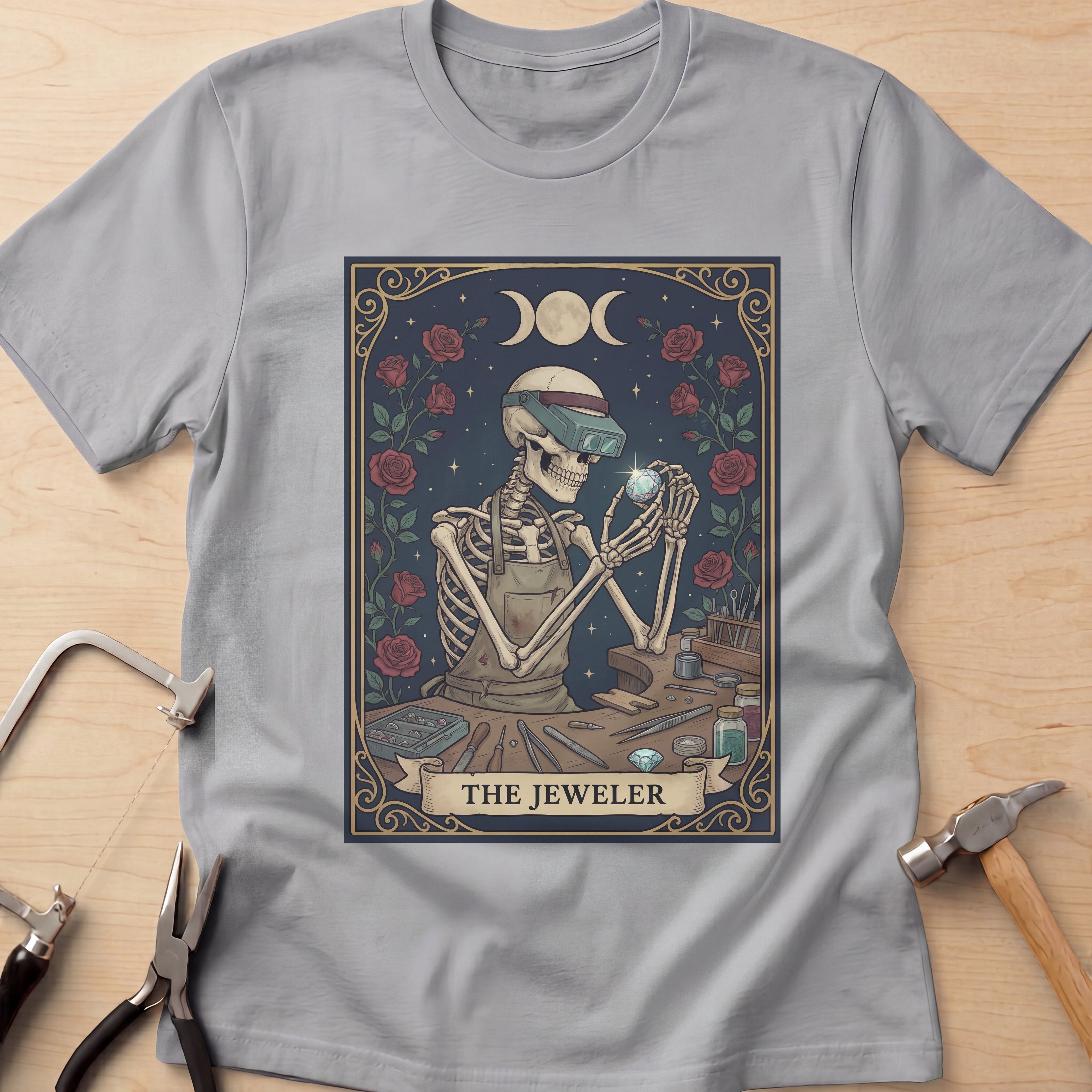 The Jeweler Tarot (Red Roses) jewelry maker t-shirt in Sport Grey, flat lay with jeweler's tools